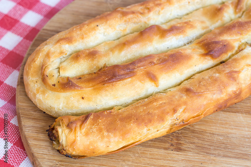 Round domestic burek pie with meat on the wooden board