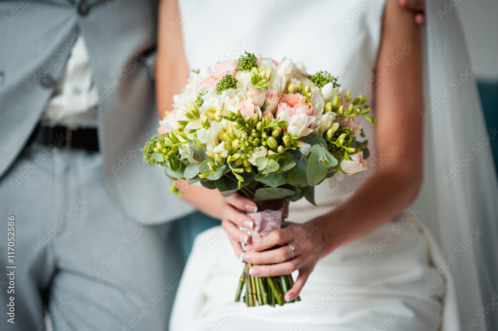 Beautiful wedding bouquet in hands of the bride Beautiful wedding bouquet in hands of the bride