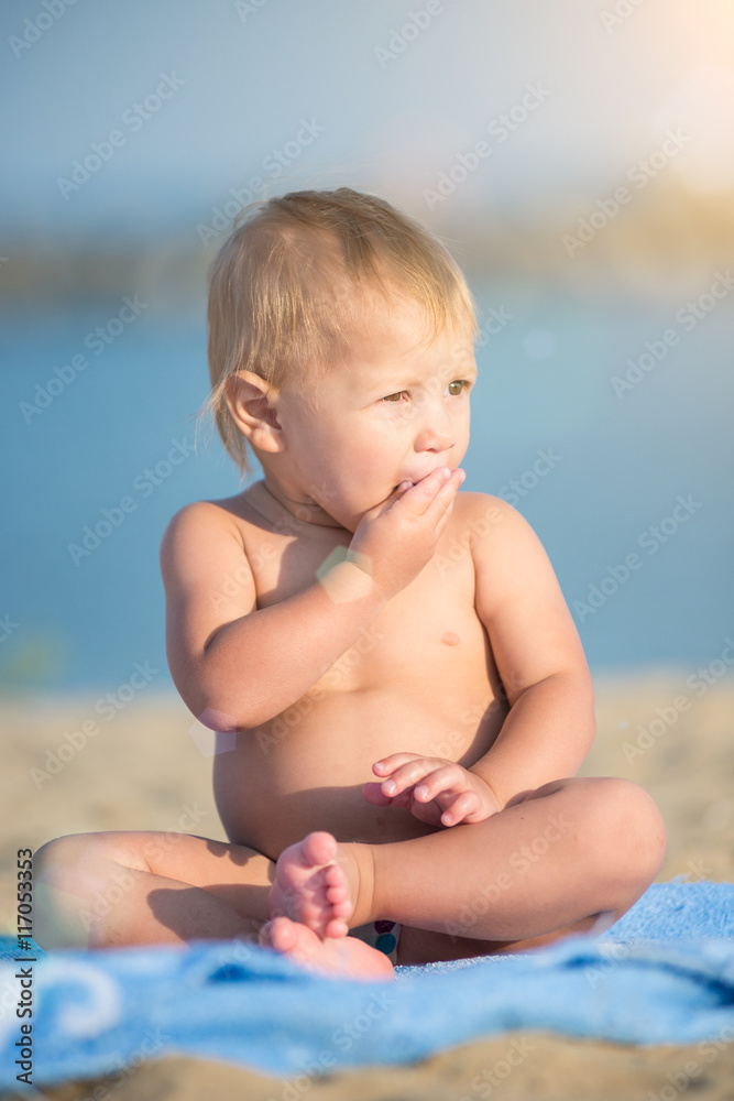 Baby playing with toys on the sandy beach near the sea. Cute little kid in  sand on tropical beach. Ocean coast.