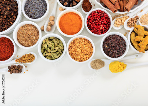 Bowls and spoons with spices on white background - copy space