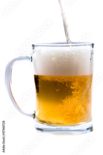 glass of light beer pouring from bottle on a white background