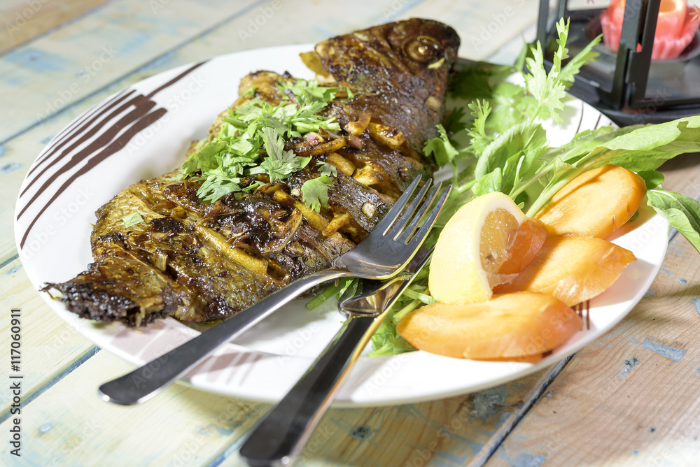 Oven Baked Tilapia fish with vegetables and Spinach. Stock Photo