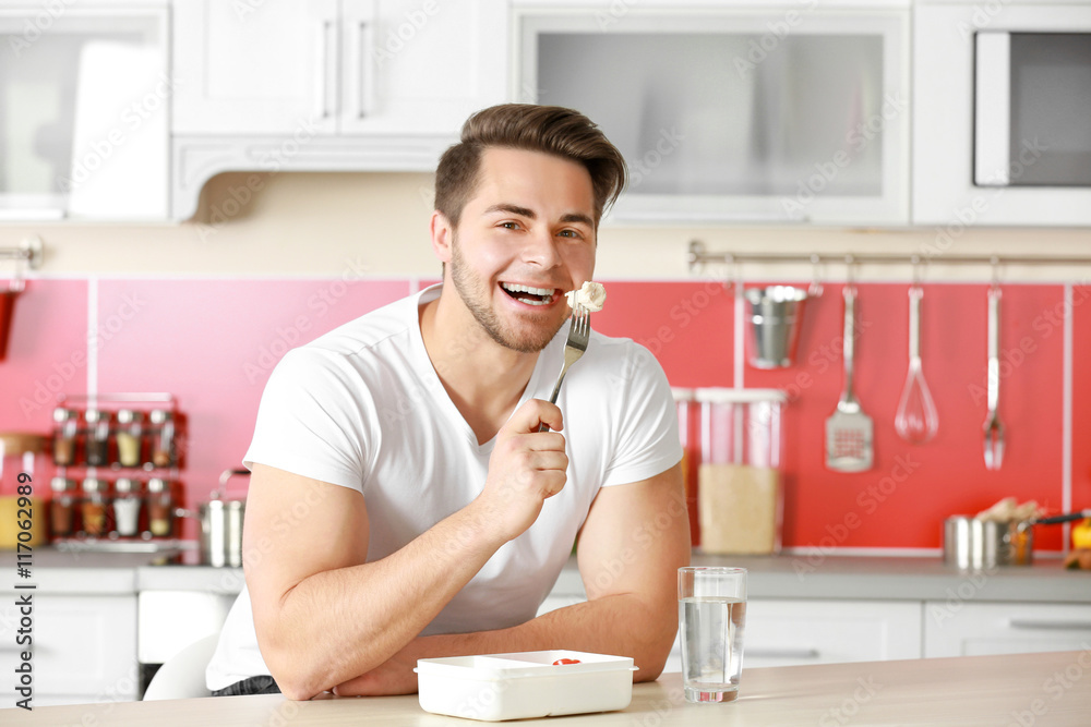 Man eating salad in the kitchen Man eating salad in the kitchen