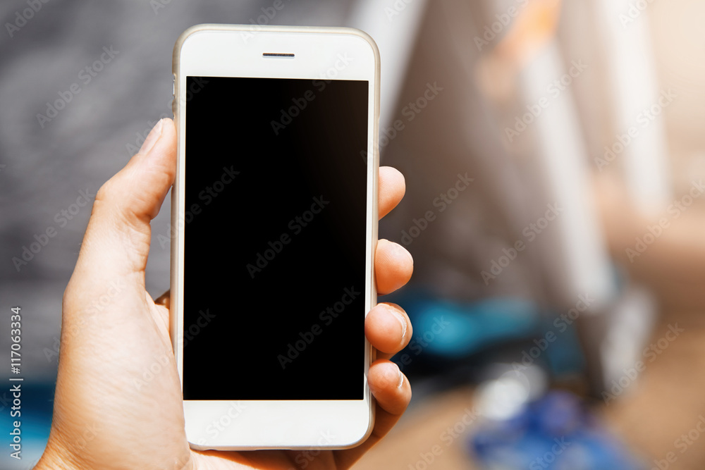 Nice close-up shot of modern gadget in hand on blur background. Beautiful phone with laconic design is a super useful device in modern era of high technologies with all mobile applications used. Nice close-up shot of modern gadget in hand on blur background. Beautiful phone with laconic design is a super useful device in modern era of high technologies with all mobile applications used.