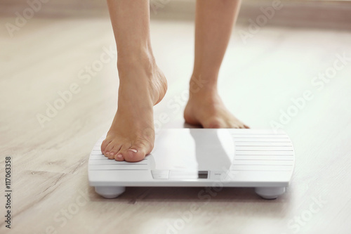 Female leg stepping on floor scales photo
