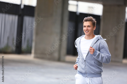 Young man running on the street © Africa Studio