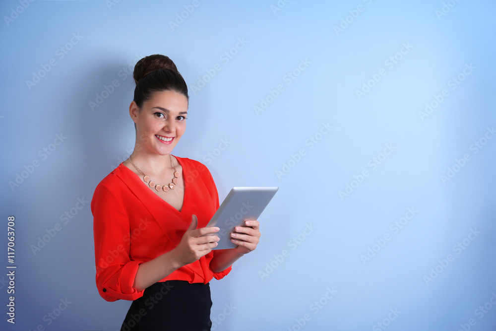 Pretty young woman holding tablet on light background Pretty young woman holding tablet on light background