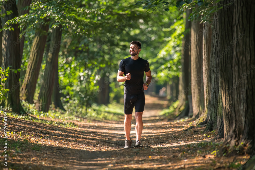 The athletic man run on the beautiful park alley The athletic man run on the beautiful park alley