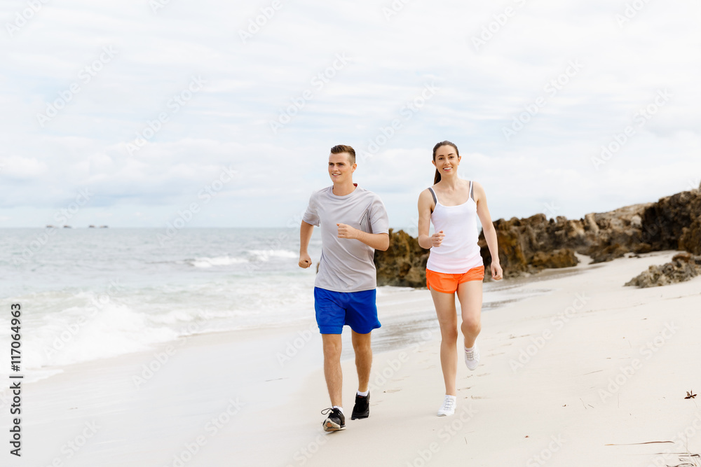 Fototapeta premium Runners. Young couple running on beach