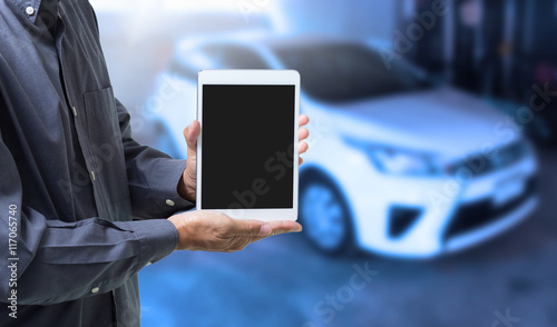 Businessman hands holding digital tablet computer with blurred car background