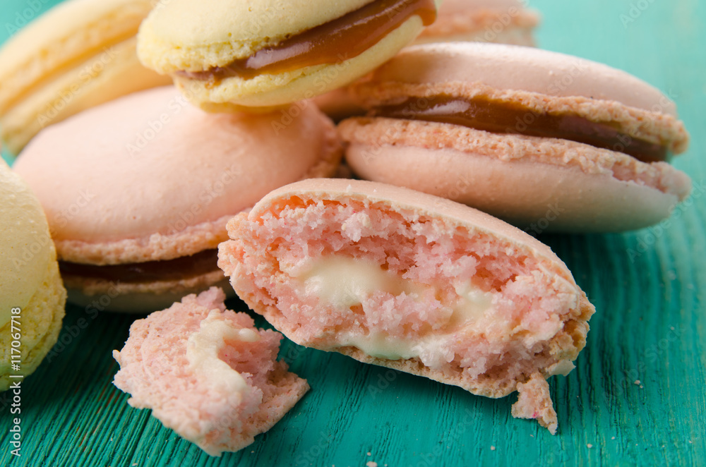 Sweet and colourful french macaroons on wood turquoise background Sweet and colourful french macaroons on wood turquoise background