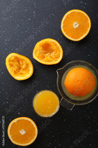 Fresh oranges juice in glass on slate background