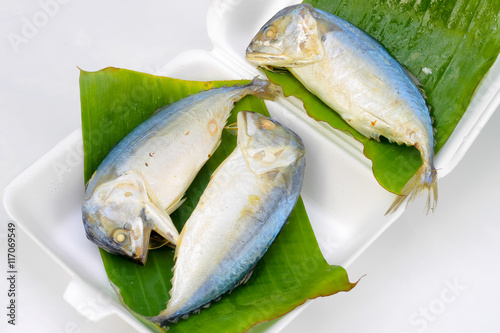 mackerel steamed on banana leaf on a white background.