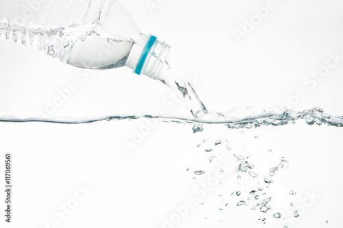 Water pouring from water bottle on white background