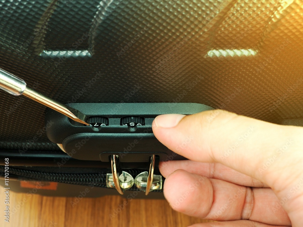 Fotografie Man hand repair suitcase combination lock.