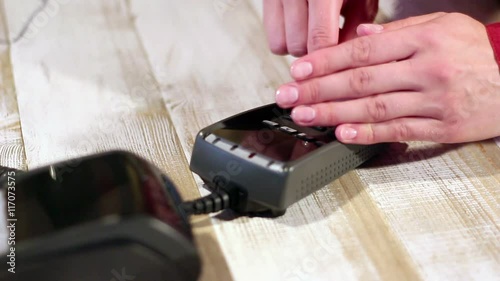 Hiding pin code with hand. Dialing pin code on pin pad of card machine