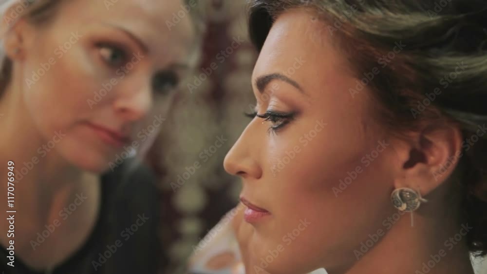 Makeup artist apply makeup to an attractive bride Makeup artist apply makeup to an attractive bride