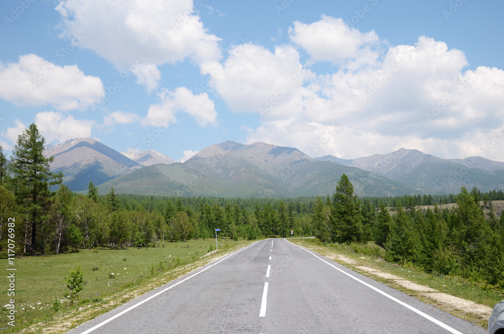 Fototapeta premium Tarmac road leading to the Sayan Mountains