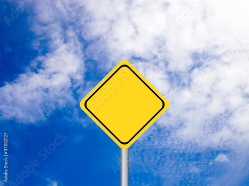 Blank yellow transportation sign on clear blue sky with white cl