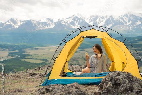 pretty girl sits in a tent on mountain