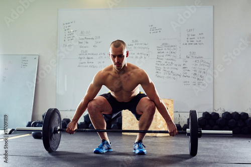 Fotografia Young athlete doing snatch exercise at the gym