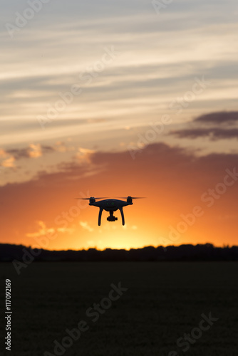 Drone silhouetted against orange sunset © tslphoto