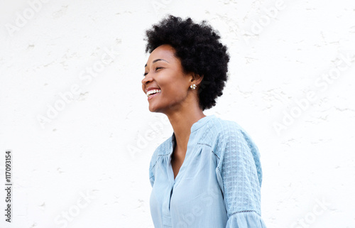 Smiling young african female against white background photo