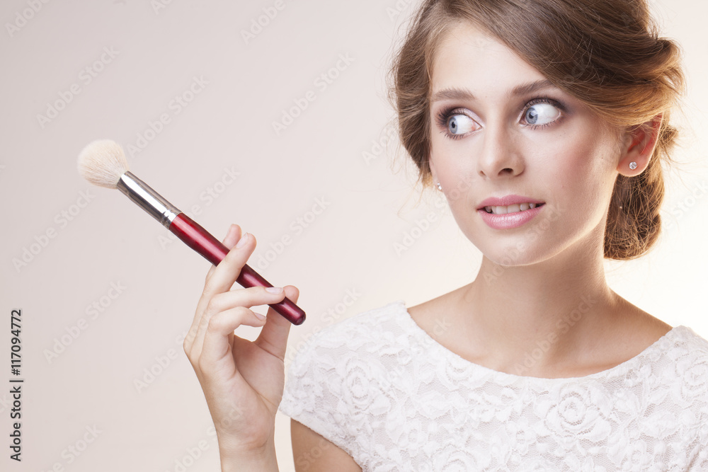 Fototapeta premium pretty girl with blue eyes and make up brush in the hand