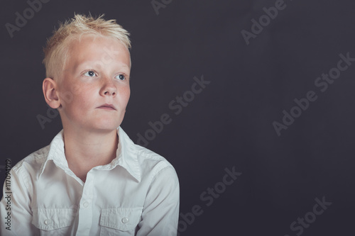 Foto Pensive young boy looking upward over black