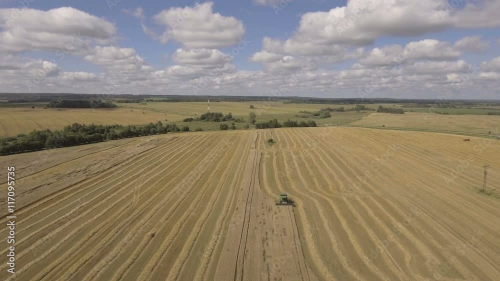 Combine harvester on a wheat field at harvest.Aerial view of agricultural land with harvester.Combine harvesting wheat.Aerial view of agricultural land with harvester. Working Harvesting Combine in Combine harvester on a wheat field at harvest.Aerial view of agricultural land with harvester.Combine harvesting wheat.Aerial view of agricultural land with harvester. Working Harvesting Combine in