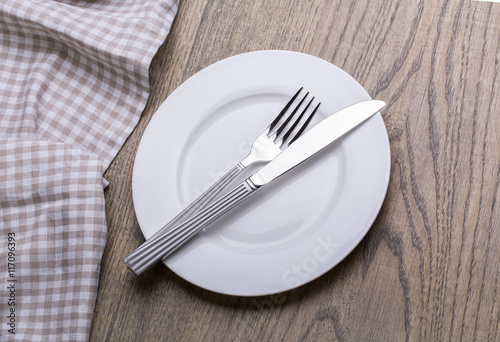 Empty plate, knife, fork and towel