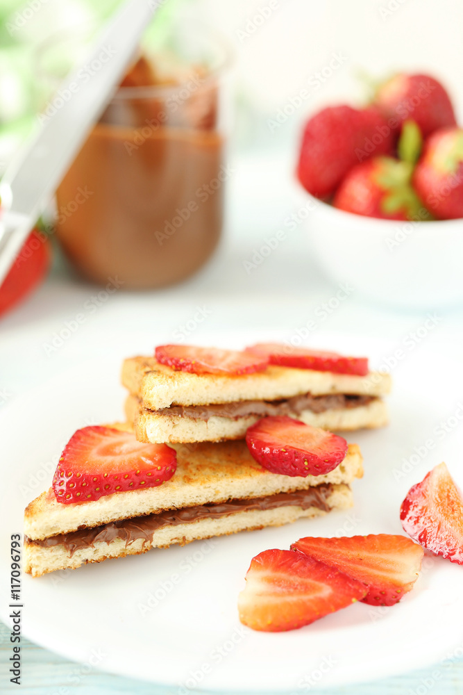 French toasts with chocolate and strawberry on wooden table French toasts with chocolate and strawberry on wooden table