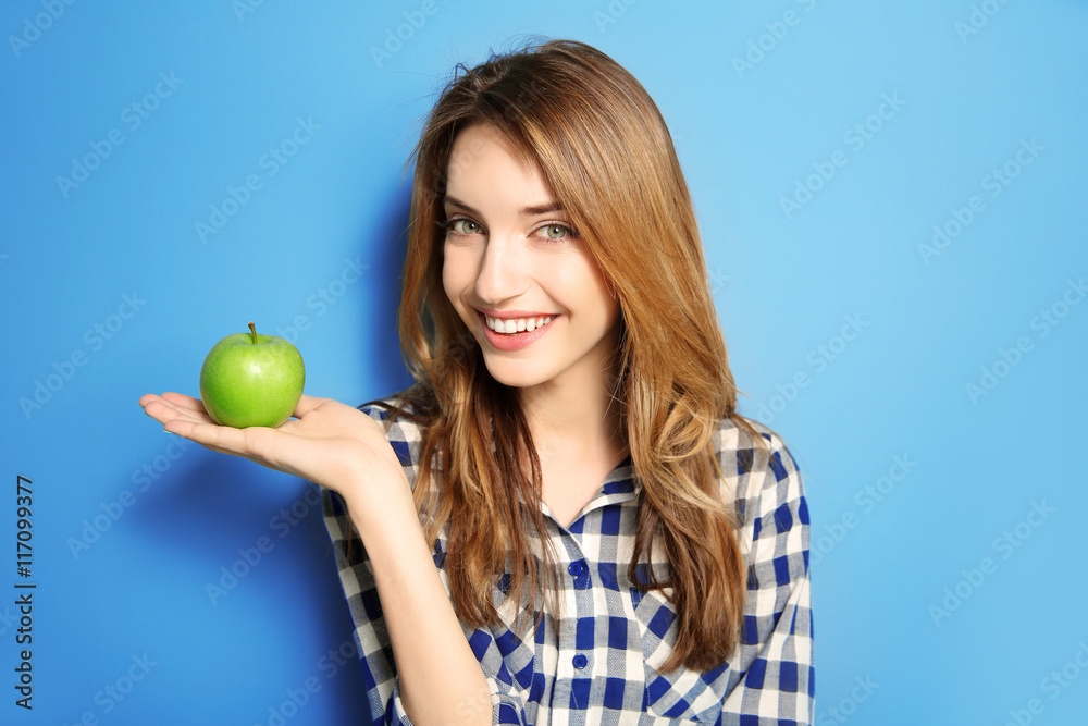 Beautiful girl with green apple on blue background Beautiful girl with green apple on blue background