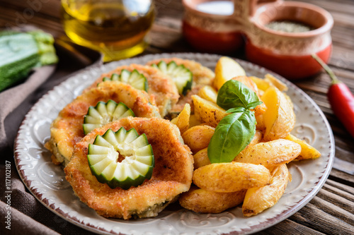 Breaded fried zucchini with American potatoes and cucumber