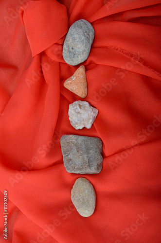 Pebbles, on red canvas background photo