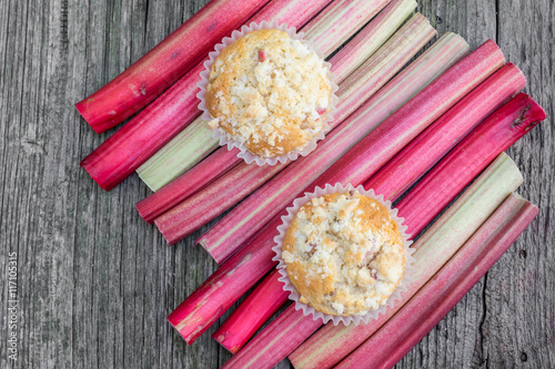 Top View on two Rhubarb muffins in paper cups on a rhubarb perio photo