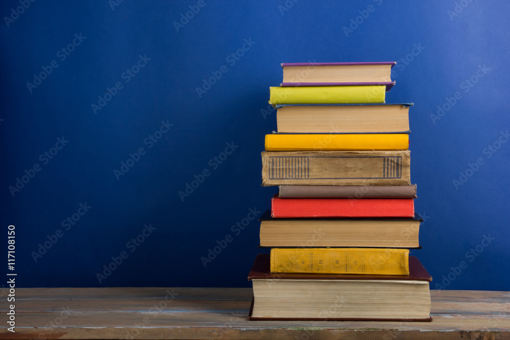 Books on grunge wooden table desk shelf in library. Back to school background with copy space for your ad text. Old hardback books with no labels, blank spine Books on grunge wooden table desk shelf in library. Back to school background with copy space for your ad text. Old hardback books with no labels, blank spine