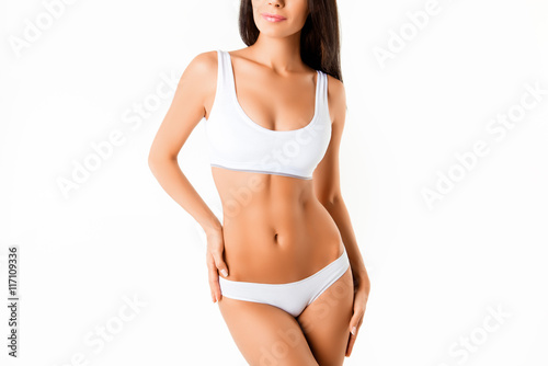 Muscular woman's body in lingerie isolated on white background