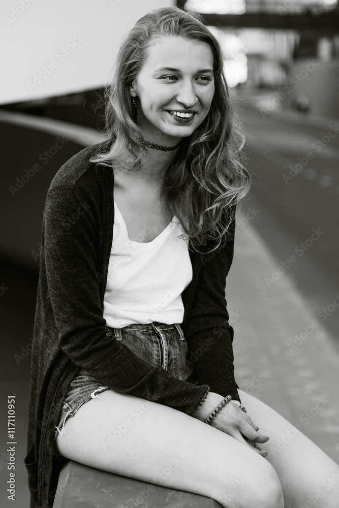 Fototapeta premium Young attractive girl sits outside