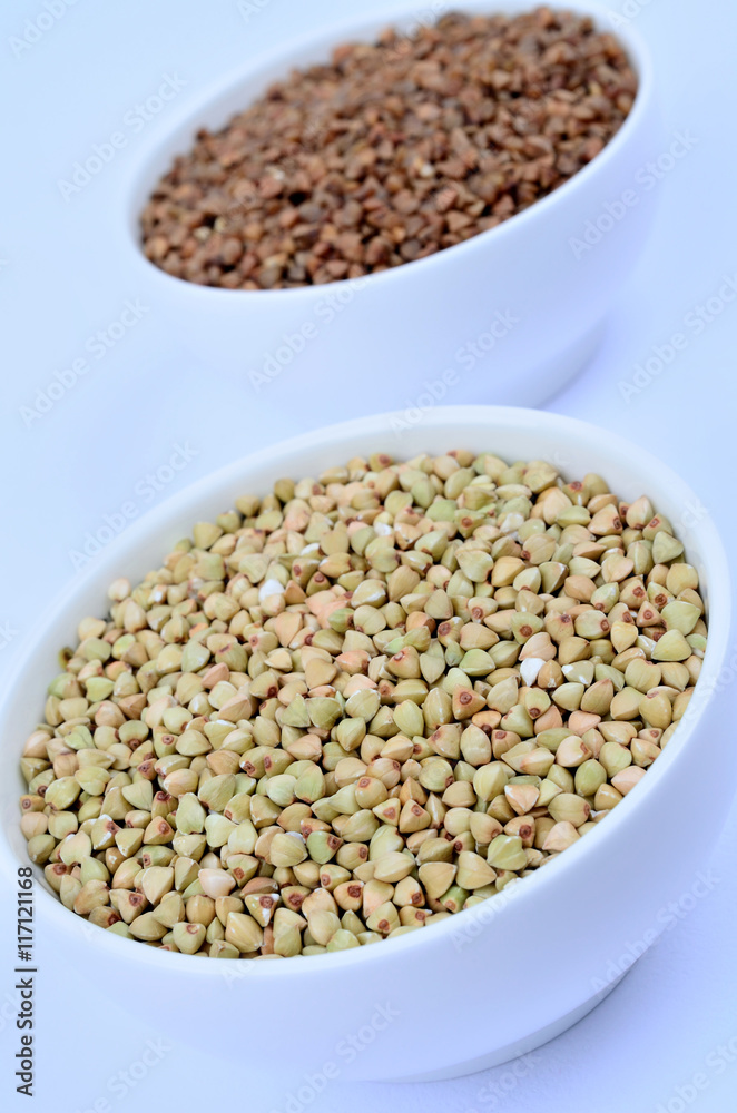 Bowls with buckwheat on background