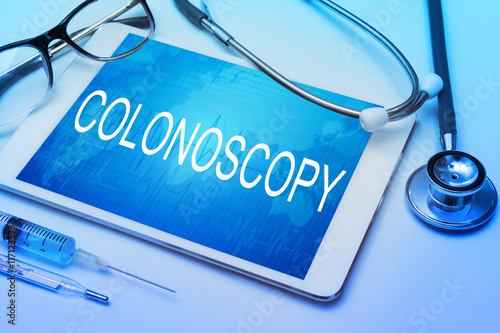 Colonoscopy word on tablet screen with medical equipment on background