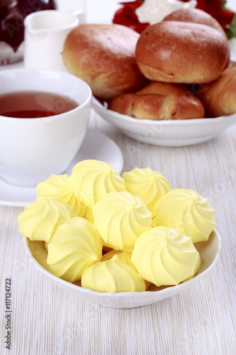 Tea party with meringue cookies and buns.