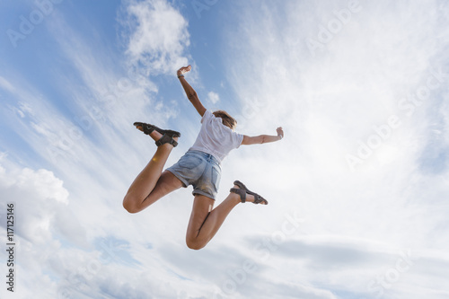 Beautiful and happy girl jumps in the sky © Kirill