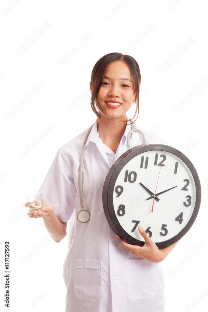 Young Asian female doctor smile with a clock and pills in hand Young Asian female doctor smile with a clock and pills in hand