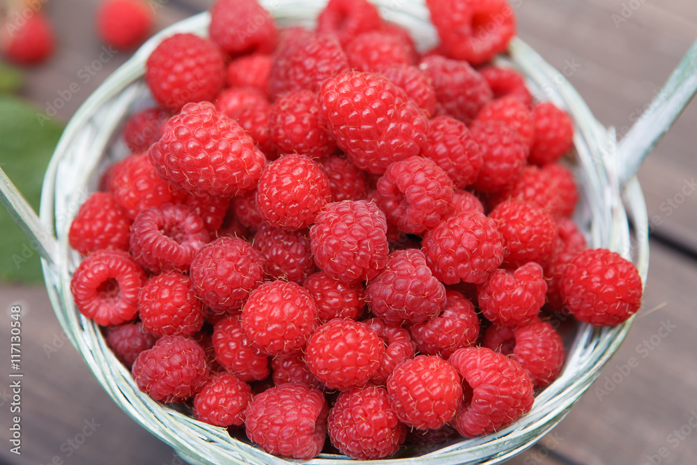 Red fresh raspberries basket on brown rustic wood background Red fresh raspberries basket on brown rustic wood background