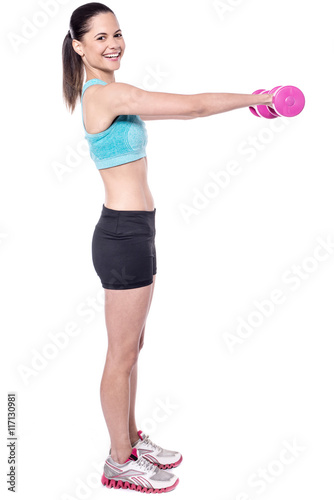 Fit smiling lady exercising with dumbbells