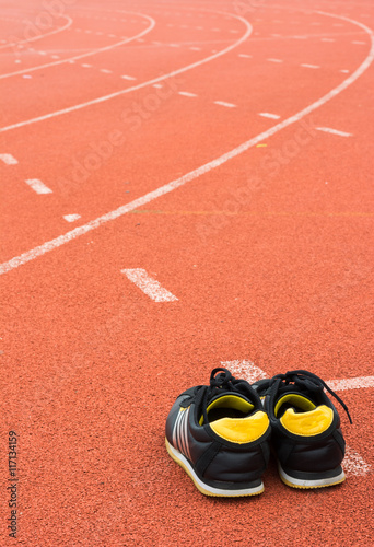 Sport shoes on running track background