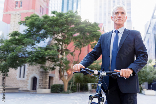 Successful businessman riding bicycle