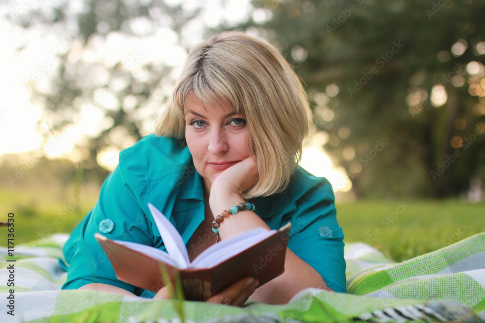 woman in park with book on the grass woman in park with book on the grass