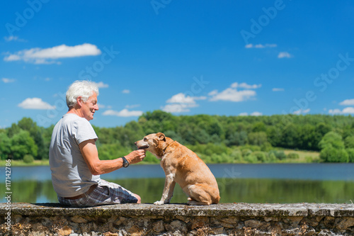 Senior man with old dog in nature landscape